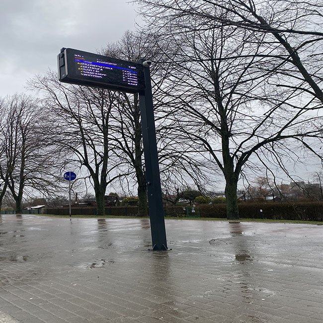 Caja metálica con pantalla de información de estación de autobuses con poste